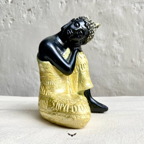 Buda de madera con túnica negro y oro.